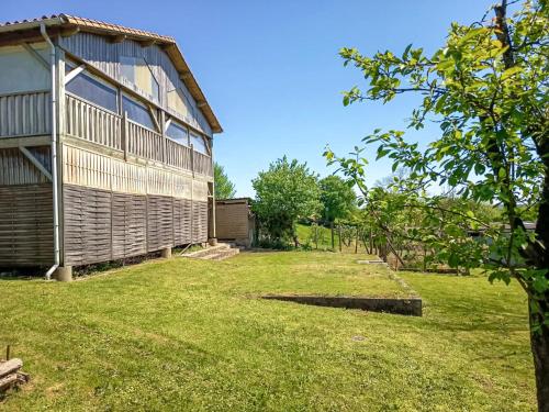 a house with a grass yard next to a building at Pavillon du Capitaine -25min Parc-By R&G in Montournais