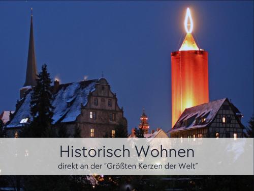 施利茨HINTERBURG SCHLITZ - Großes Burgen-Apartment mit 4 Schlafzimmern & 2 Bädern - ideal für Familien und Gruppen, inklusive kostenloser Parkplätze, Aufzug und Garten的建筑物顶部的钟楼，上面点燃着蜡烛。