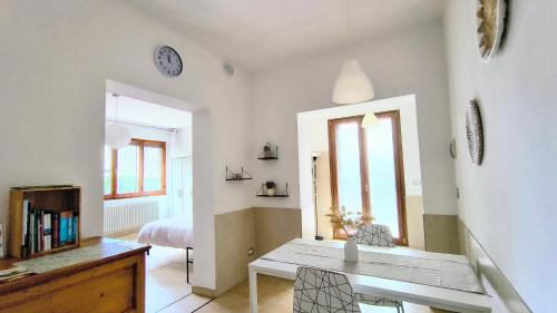 a living room with a table and a bedroom at Maya Suite & Garden in Sarteano