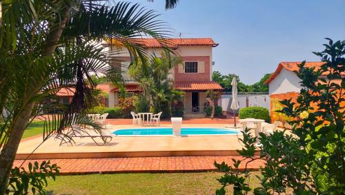 a house with a swimming pool in the yard at Village Itaúna Inn - Casas de Temporada in Saquarema