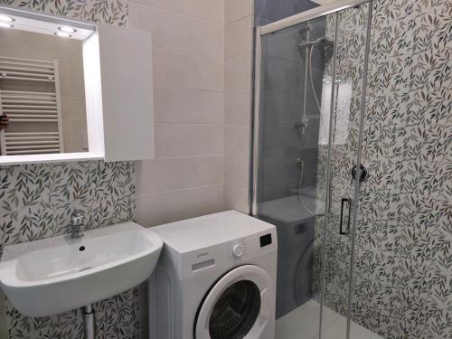 a bathroom with a washing machine and a sink at Casa Quarzo, bright and a stone's throw from the beach in Gaeta