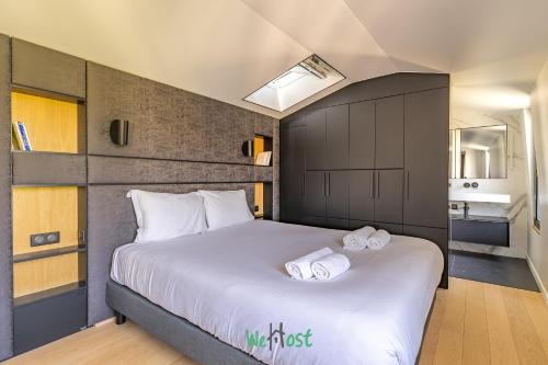 una camera da letto con un letto grande con due asciugamani sopra di Raspail B - IDF - LB - Charming house at gates of Paris 3 people a Bois-Colombes