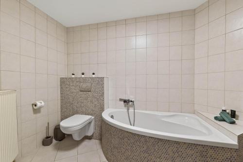 布雷滕Lara - Stilvolle 3-Zimmer-Unterkunft im Herzen von Bretten的带浴缸和卫生间的浴室