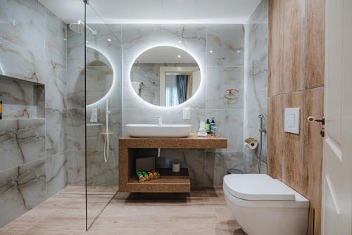 un bagno con lavandino, WC e specchio di Averde Residence a Larnaka