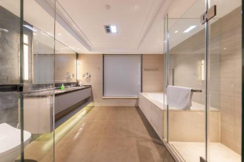 成都市にあるChengdu Botingxi Mansion Selected Suites B&Bのガラスのシャワーと洗面台を備えたバスルーム