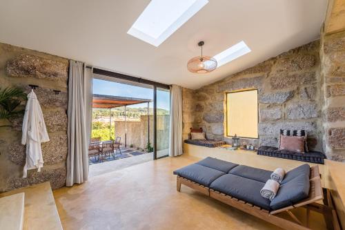 a living room with a couch and a stone wall at Lemon Villa with Private Indoor Heated Pool - Oporto Lemon Farm, near Porto in Valpedre