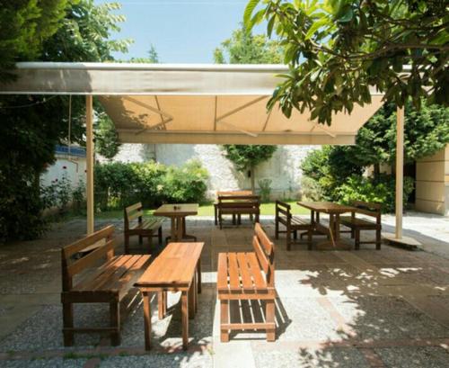 a group of picnic tables and benches under a pavilion at Hotel Baylan İzmir in Izmir