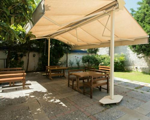 a table and benches under a large umbrella at Hotel Baylan İzmir in Izmir