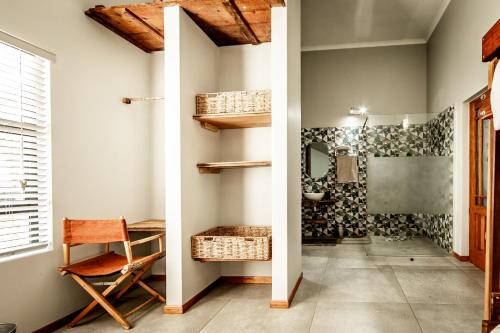 un couloir avec une salle de bain équipée d'une table et d'une chaise dans l'établissement Zoetvlei Dairy House, à Paterson