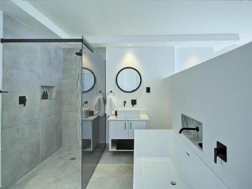 a white bathroom with a shower and a sink at Mossel-Bay Waterfront Accommodation in Linkside
