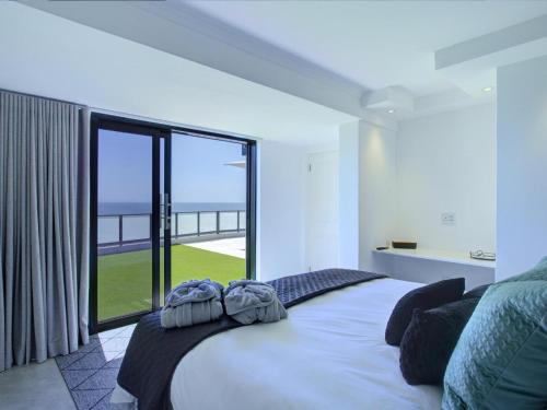 a bedroom with a large bed with a large window at Mossel-Bay Waterfront Accommodation in Linkside