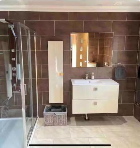 a bathroom with a sink and a shower at Modern timber clad house in Stornoway