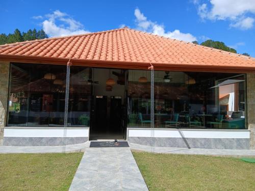 a building with an orange tiled roof at Pequena Suíça Hotel Boutique in Chácara