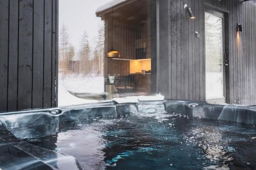 una vasca idromassaggio in una stanza con neve di Tyven Resort a Sirkkakoski