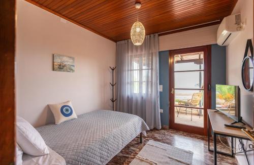 Μια τηλεόραση ή/και κέντρο ψυχαγωγίας στο Villa Psani - Beachfront Escape with Garden