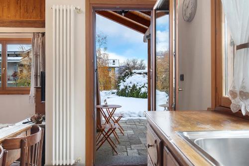eine Küche mit einer Glasschiebetür zu einer Terrasse in der Unterkunft Au Petit Chevrot - Garden in Aosta