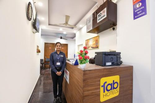 Uma mulher em pé em frente a um escritório da Job Horizons. em FabHotel NP International - Nehru Place Market em Jāmb