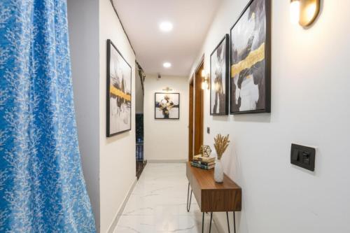 um corredor com quadros nas paredes e uma mesa em FabHotel NP International - Nehru Place Market em Jāmb