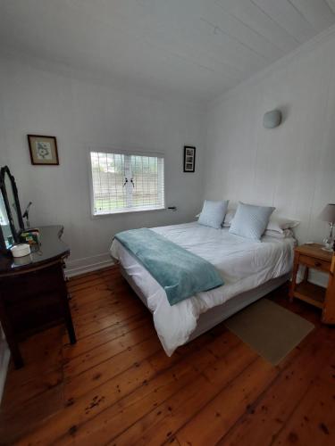 a bedroom with a large bed and a window at Coda in Umkomaas