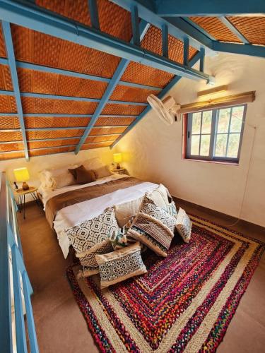 ChanereにあるThe Rudraksh Villa - Farmers Deckの大きなベッドとラグのある寝室