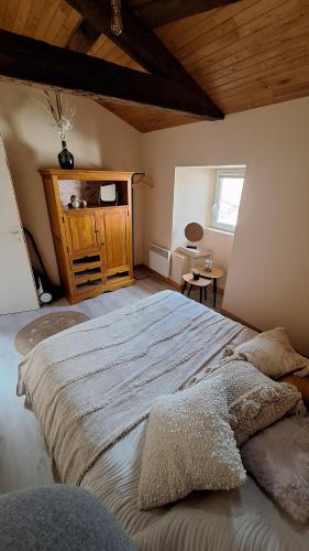 una camera da letto con un letto grande con soffitto in legno di La tête dans les étoiles a Ruffec