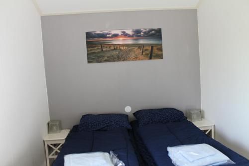 una camera da letto con due letti e un quadro sul muro di Weideveld 60 Michelle a Den Burg