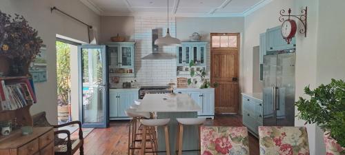 Una cocina con gabinetes azules y una mesa blanca. en KayaLami, en Oudtshoorn