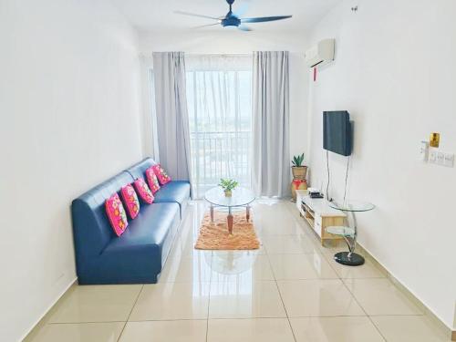 a living room with a blue couch and a table at Metropol Serviced Apartment Nice Pool View 3 BR in Bukit Mertajam