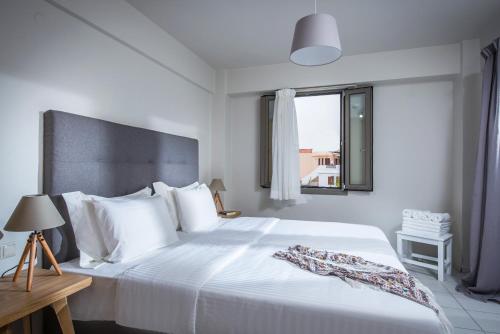 a bedroom with a large white bed with a window at Bianca Doma Adults Only by Estia in Hersonissos