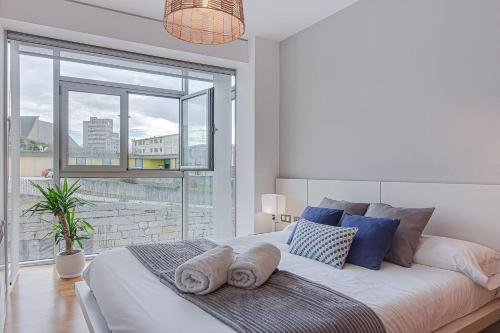 a bedroom with a large bed with a large window at Blue Ocean Apartment in A Coruña