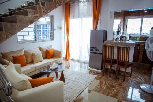 Una sala de estar con un sofá y una cocina. en InfiniStay, en Abiyán