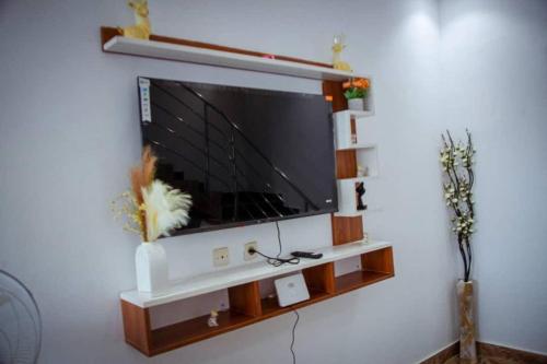 TV de pantalla plana en la pared de la sala de estar. en InfiniStay, en Abiyán