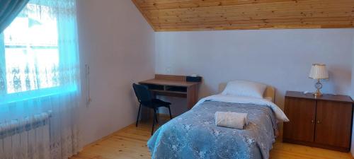 ein Schlafzimmer mit Bett, Schreibtisch und Fenster in der Unterkunft Beloved Home in Çilǝgir