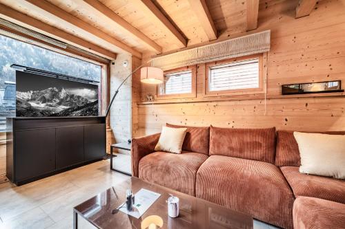 Chalet Inari Chamonix - by EMERALD STAY في شامونيه مون بلان: غرفة معيشة مع أريكة وتلفزيون بشاشة مسطحة