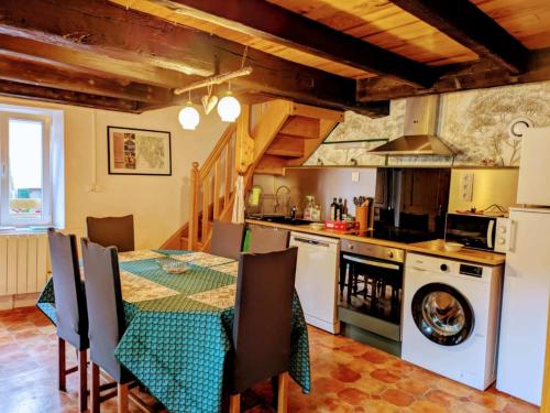 TenaySous les Etoiles du Bugey的一间带桌子的厨房和一间带炉灶的厨房