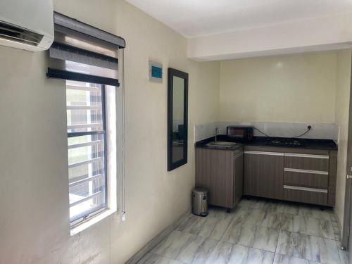 a small kitchen with a counter and a window at House 32 Hotels and Suites in Lagos