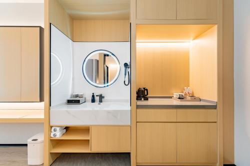 a bathroom with a sink and a mirror at Jin Yi X Hotel in Hekou