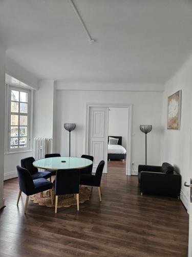 a living room with a table and chairs and a bed at Grand appartement de 140m2 en plein centre-ville in Strasbourg