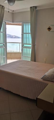 Itapema beira mar في ايتابيما: سرير كبير في غرفة نوم مطلة على المحيط