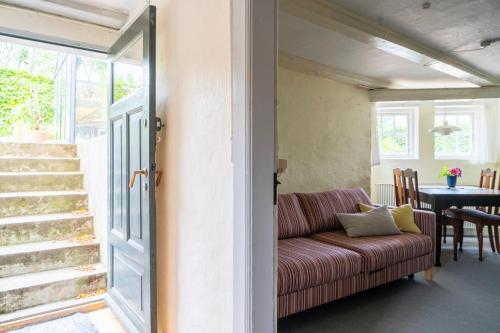 a living room with a couch and a table at Lyst og rummeligt kælderværelse med egen indgang og parkering in Brabrand