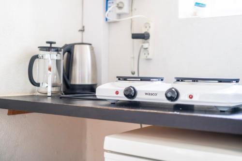 a kitchen counter with a stove and a coffee maker at Lyst og rummeligt kælderværelse med egen indgang og parkering in Brabrand