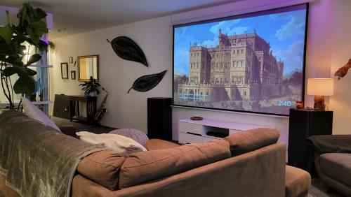 a living room with a couch and a large screen tv at Stylish Home within Central Wellington - Free Parking in Wellington