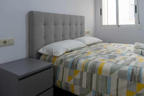 a bedroom with a large bed with a large headboard at Apartalux Villa Playa in Benidorm
