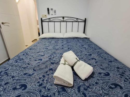 a bed with two towels sitting on top of it at Apartalux Villa Playa in Benidorm