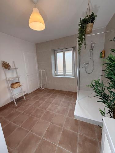 a bathroom with a shower and a tiled floor at Colmar St Joseph Nature Cocoon in Colmar