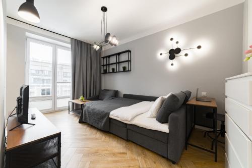 Un dormitorio con una cama, un escritorio y un televisor. en Apartament w Centrum Warszawy - Dworzec Centralny, en Varsovia