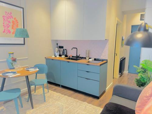 Una cocina con fregadero y una mesa con sillas. en Central Comfort Studio, en Itʼkhvisi