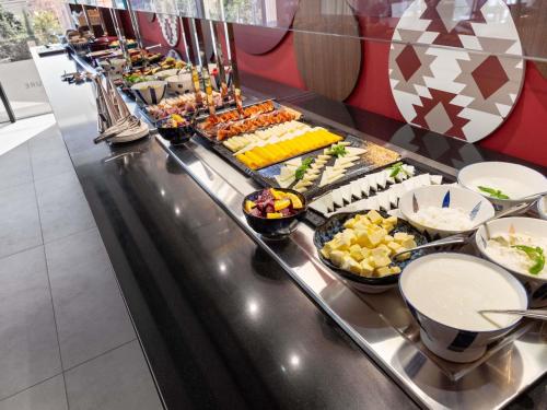 um buffet com muitos tipos diferentes de comida em Mercure Tirana em Tirana
