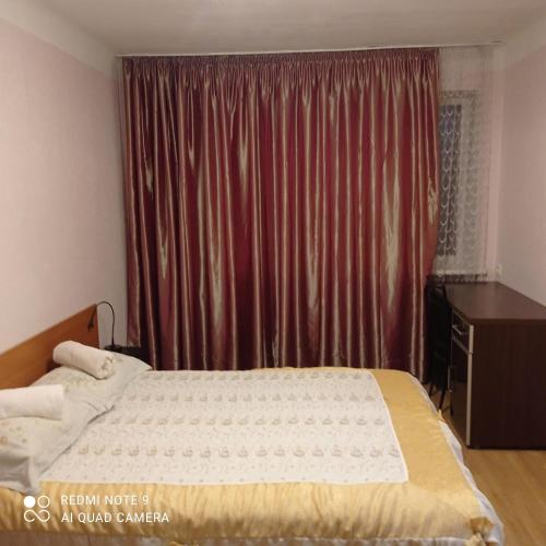 a bedroom with a bed and a red curtain at Vienības 28 in Daugavpils