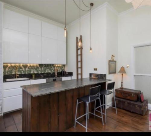 - une cuisine avec un comptoir et des tabourets dans l'établissement Park Crescent Brighton, à Brighton et Hove